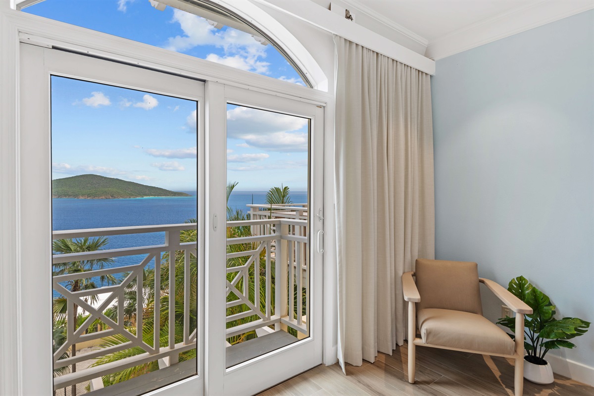 Primary suite with AC, king bed, en-suite bath, large windows, and ocean views. Ideal for privacy and relaxation.