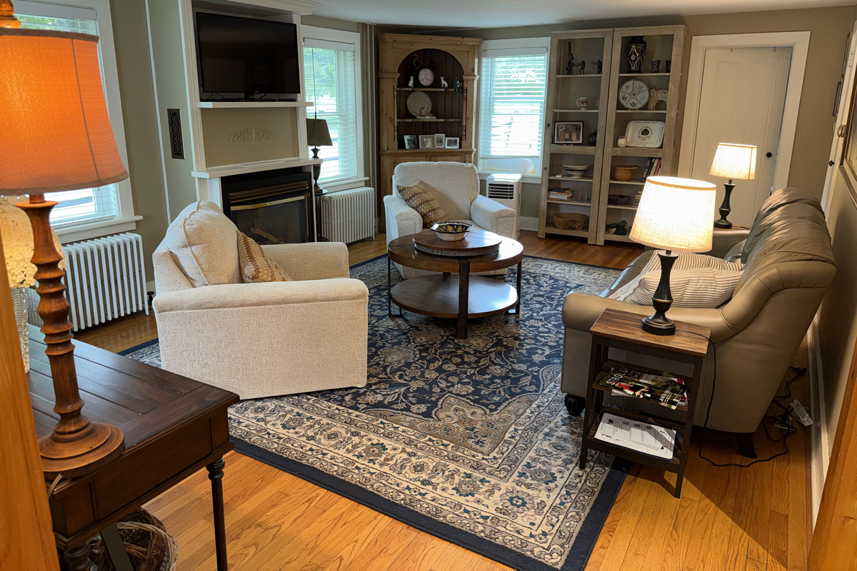 Cozy, light-filled living room with comfortable seating, beautiful hardwood floors, and charming built-in details.