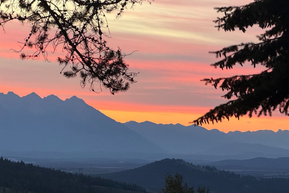 Mountain Panorama: A breathtaking east-facing view from the private deck overlooking the Rocky Mountain range during a golden sunrise.