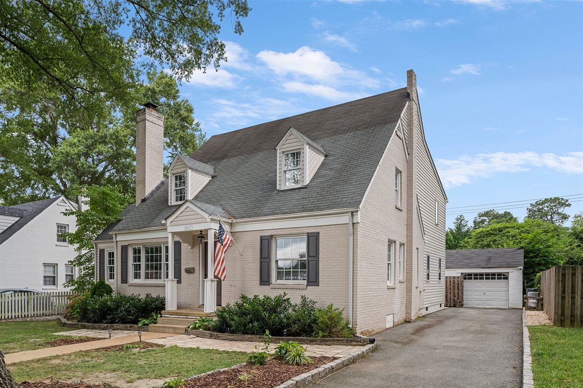 Charming Exterior: Enjoy the inviting curb appeal with lush greenery and classic design!