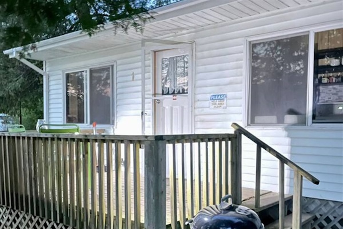 Cottage #1 exterior with deck and surrounding greenery