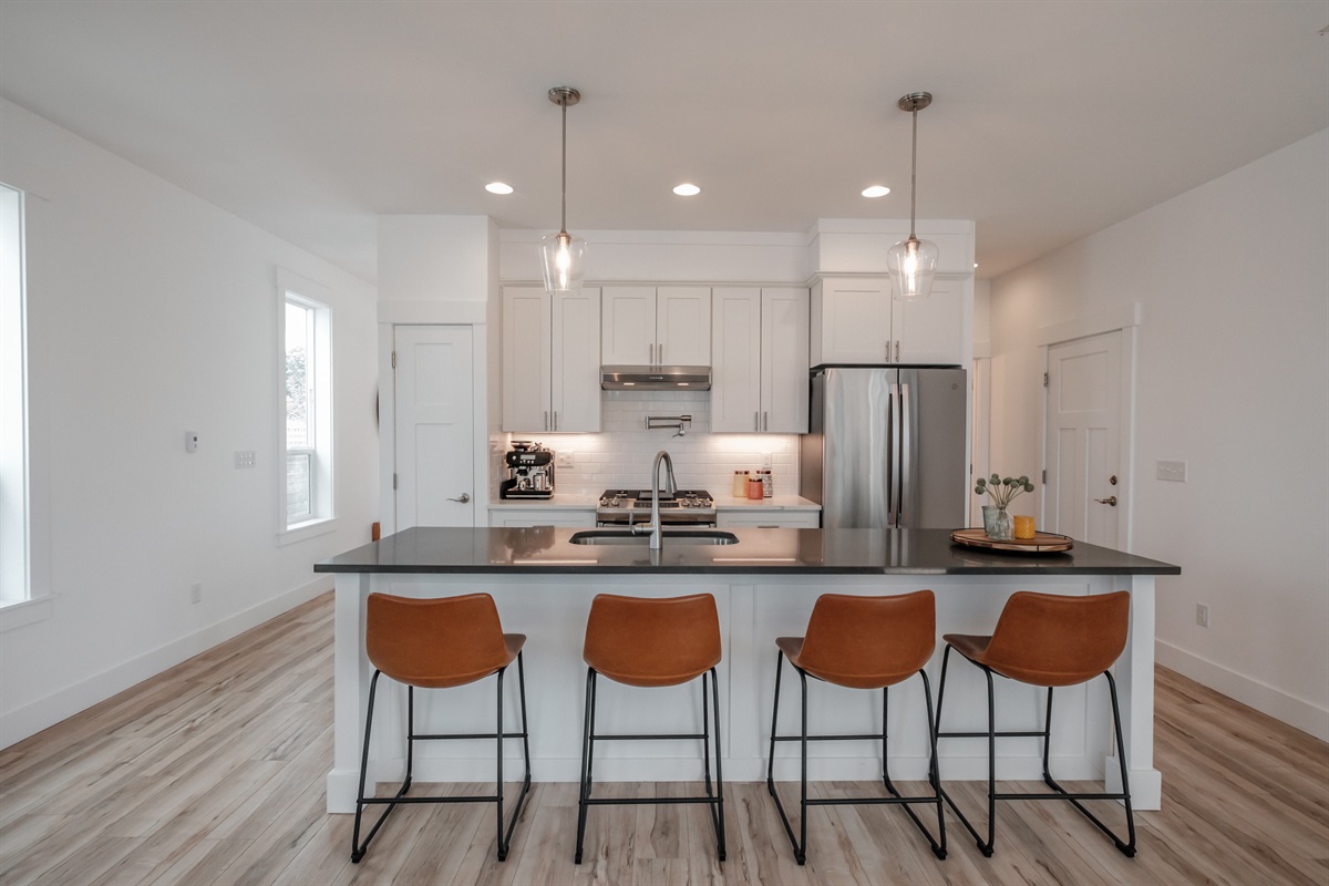 The expansive island offers relaxed seating for four, creating a perfect gathering spot for morning coffee or evening conversation.