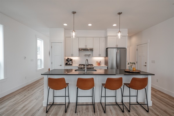 The expansive island offers relaxed seating for four, creating a perfect gathering spot for morning coffee or evening conversation.