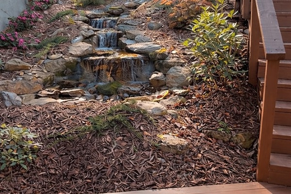 A custom-built cascading waterfall welcomes you at the front of the home—a peaceful, unexpected showpiece that sets the tone for your stay. You can hear a gentle sound of flowing water while in the living room and on the back deck.