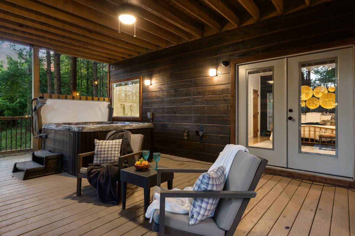 Unwind on the spacious covered deck featuring a private hot tub, cozy seating area, and peaceful forest views—perfect for morning coffee, evening drinks, or a relaxing soak under the pines. 🌲✨🛁