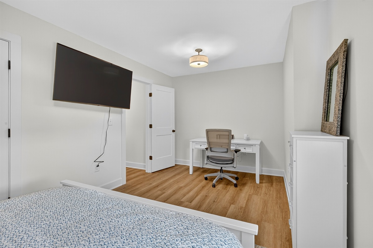 Featuring a queen bed and a work-from-home setup, this room balances comfort and productivity.