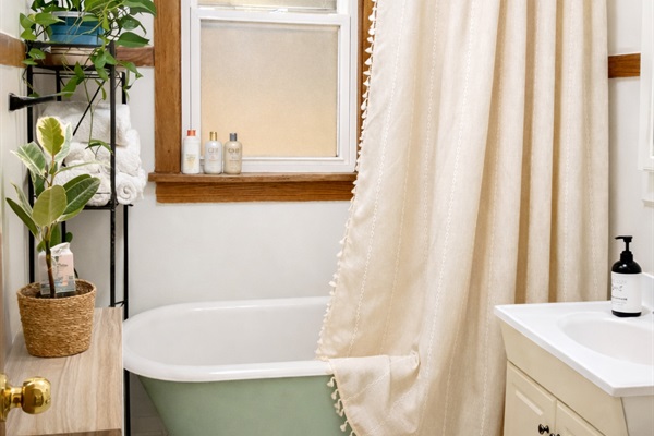 Clean, bright bathroom with full tub/shower and fresh hotel-style towels for comfortable, reliable stay.