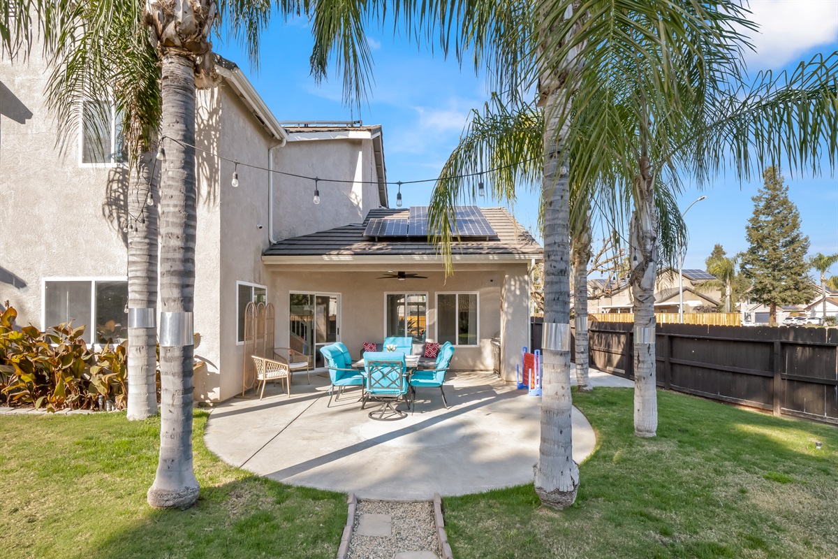 Enjoy outdoor living year-round with a covered seating area and ceiling fan for added comfort.