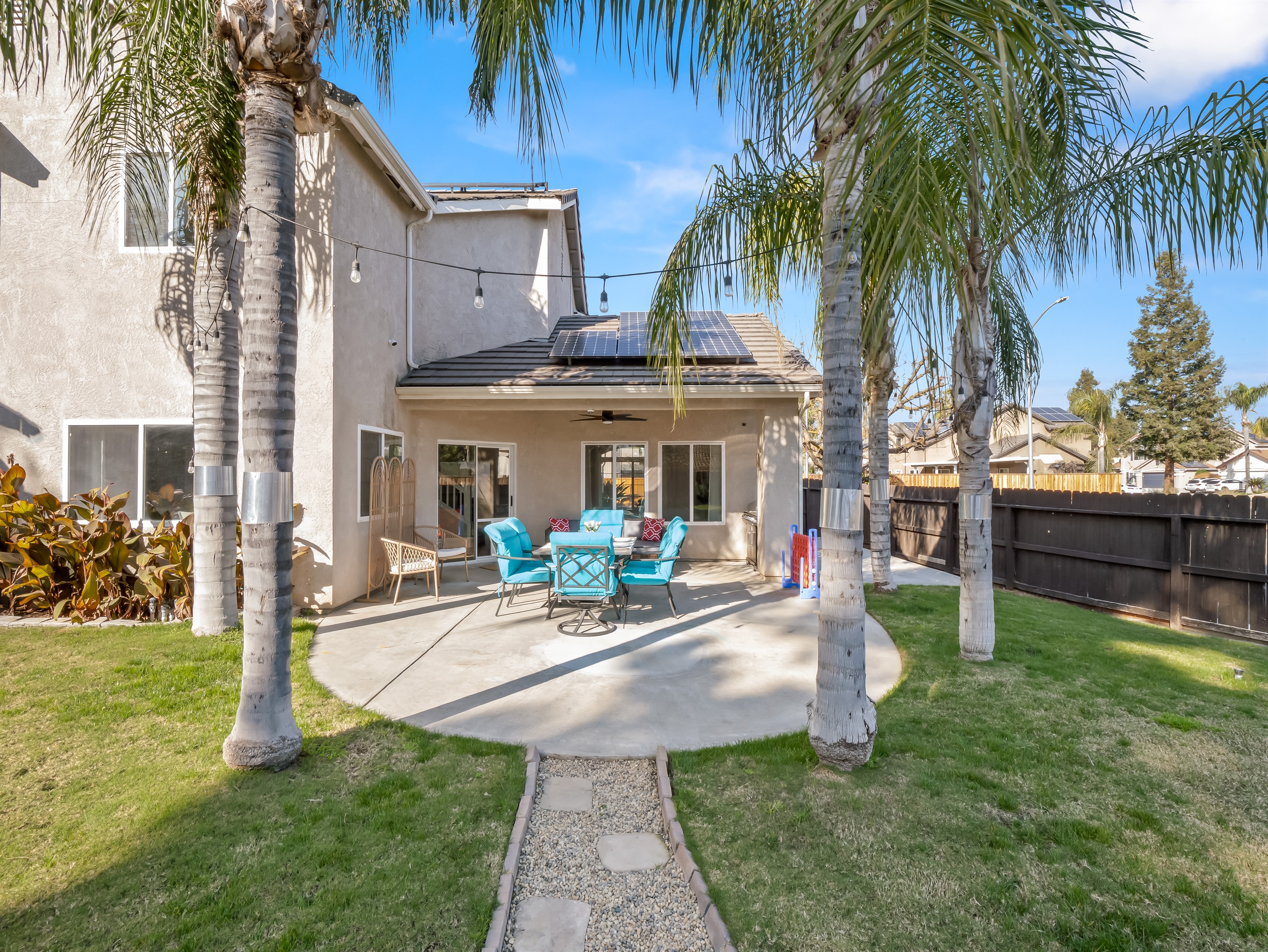Enjoy outdoor living year-round with a covered seating area and ceiling fan for added comfort.