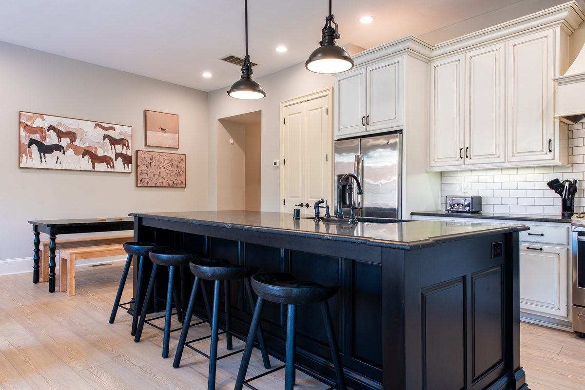 Fully equipped kitchen with stainless appliances, gas range, and a large center island with seating.