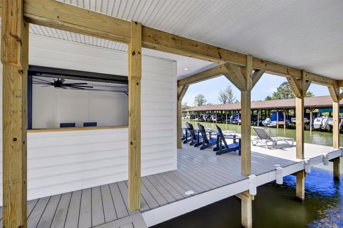 Covered waterfront walkway connects the entertaining space, boat slips, and open sundeck.