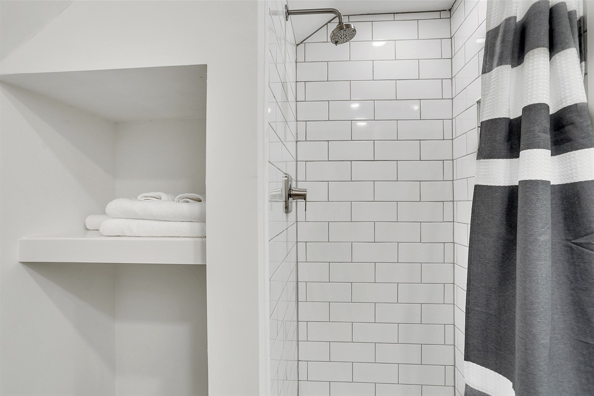 The tiled shower offers a fresh, modern feel—perfect for starting or ending your day with ease.