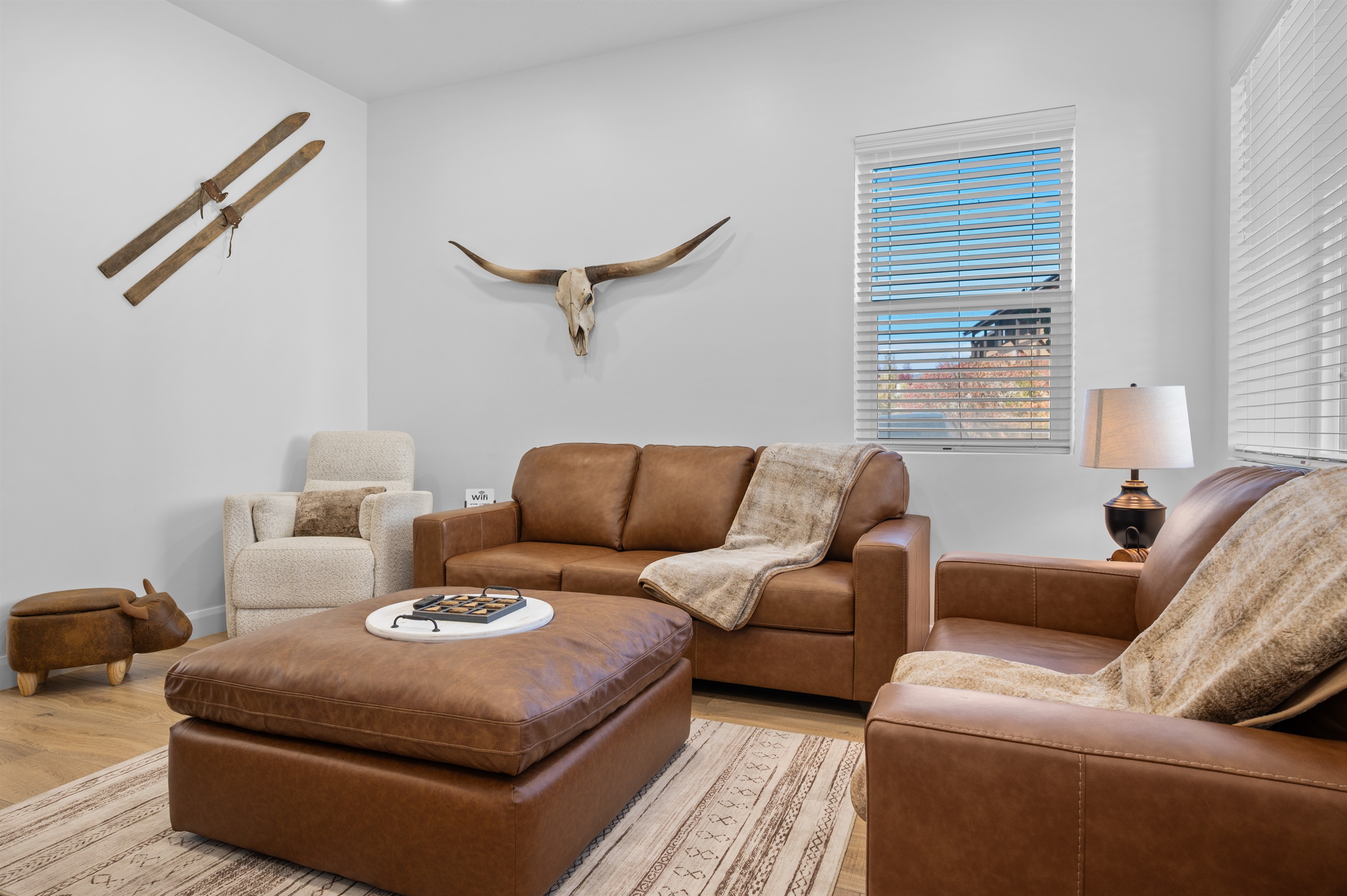 Spacious living area with plush leather furniture and natural light.