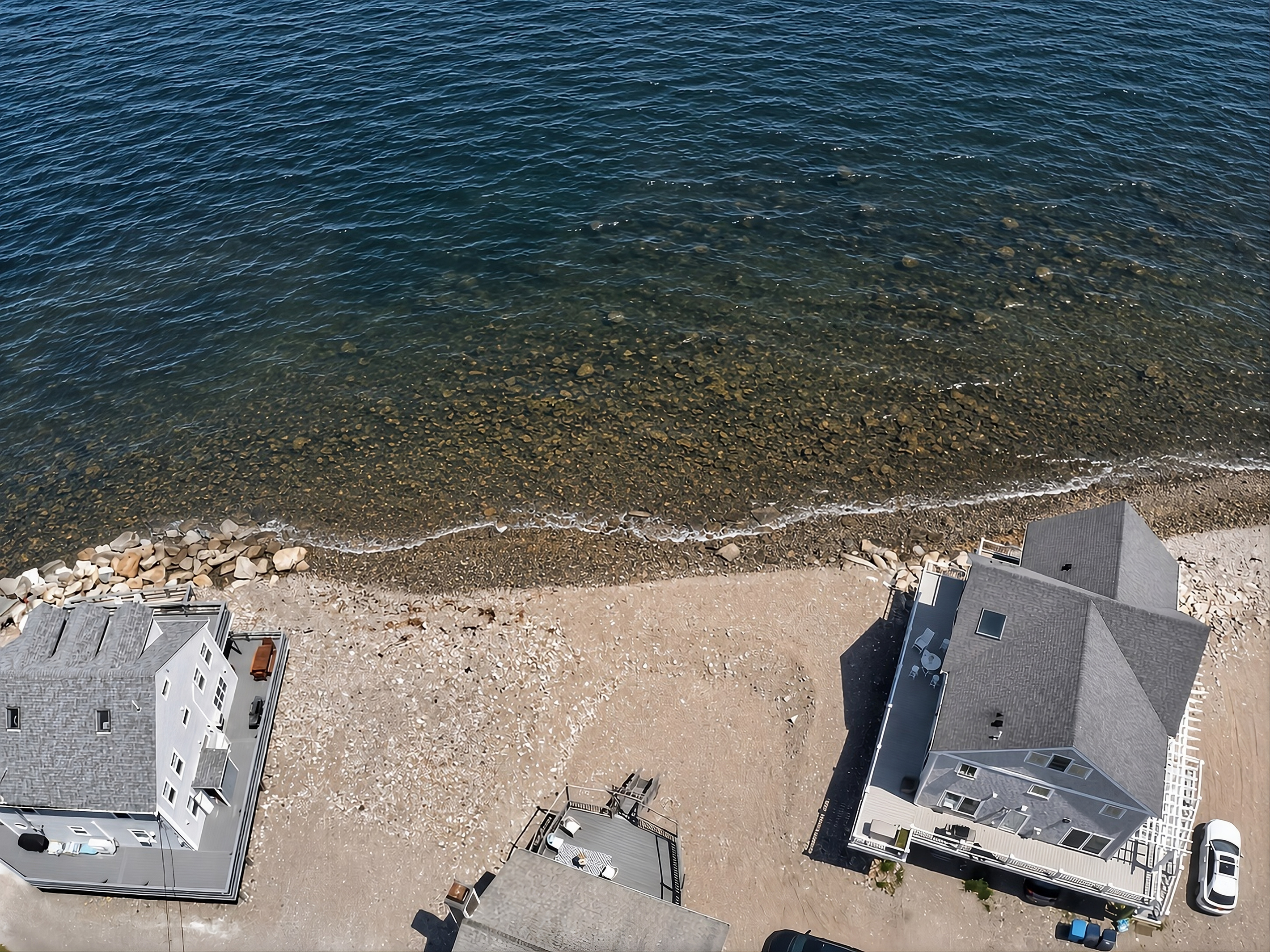 Aerial view showcasing the home’s incredible location just steps from the shoreline.