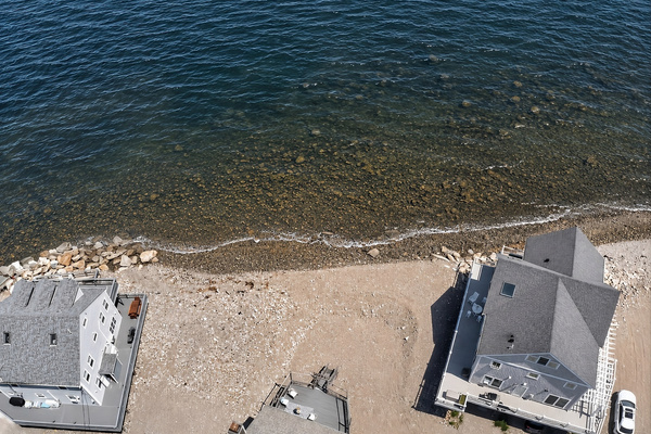 Aerial view showcasing the home’s incredible location just steps from the shoreline.
