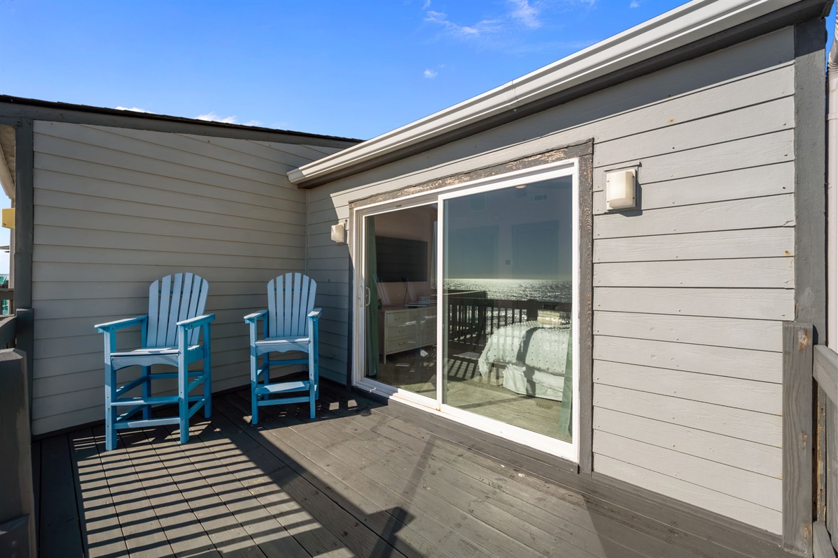 Private deck off the master bedroom with seating and ocean views&mdash;an easy spot for morning coffee or evening breezes