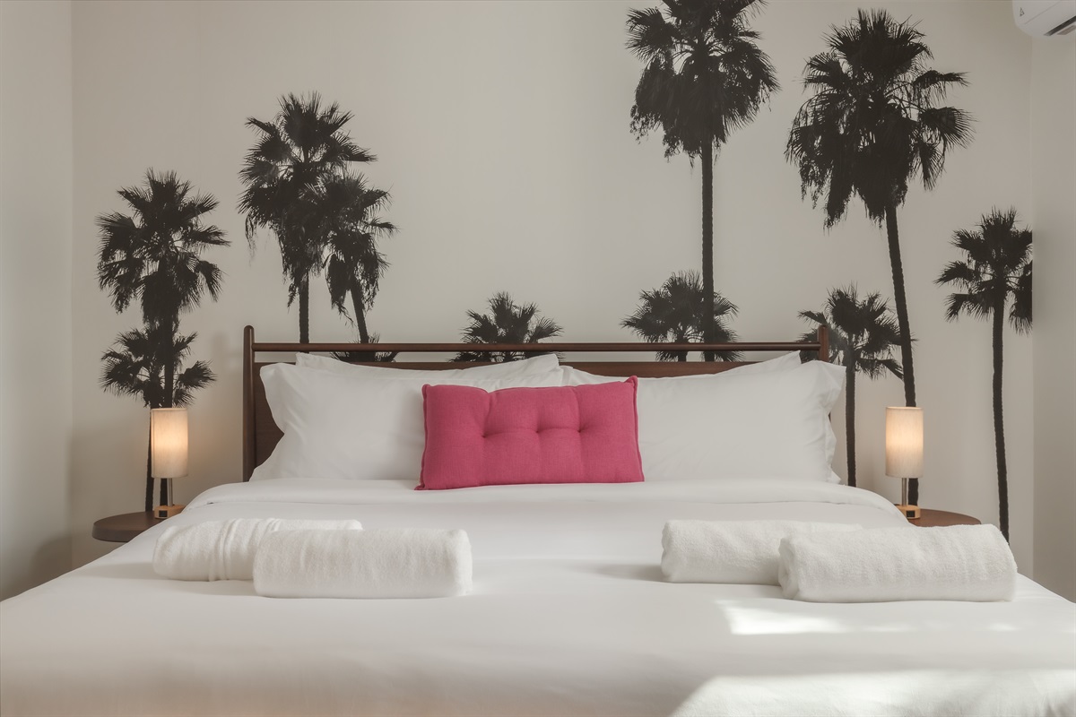 Imagine coming home from a sun-soaked day at the San Diego Zoo  and sinking into this plush king bed, framed by iconic SoCal palms.