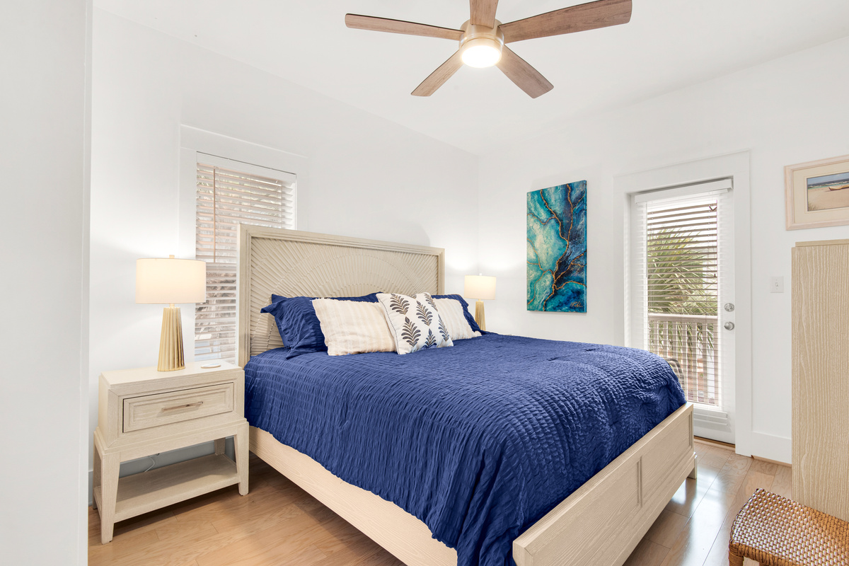Seagrove Bungalow 103 bedroom with blue bedding, bedside tables and a ceiling fan.