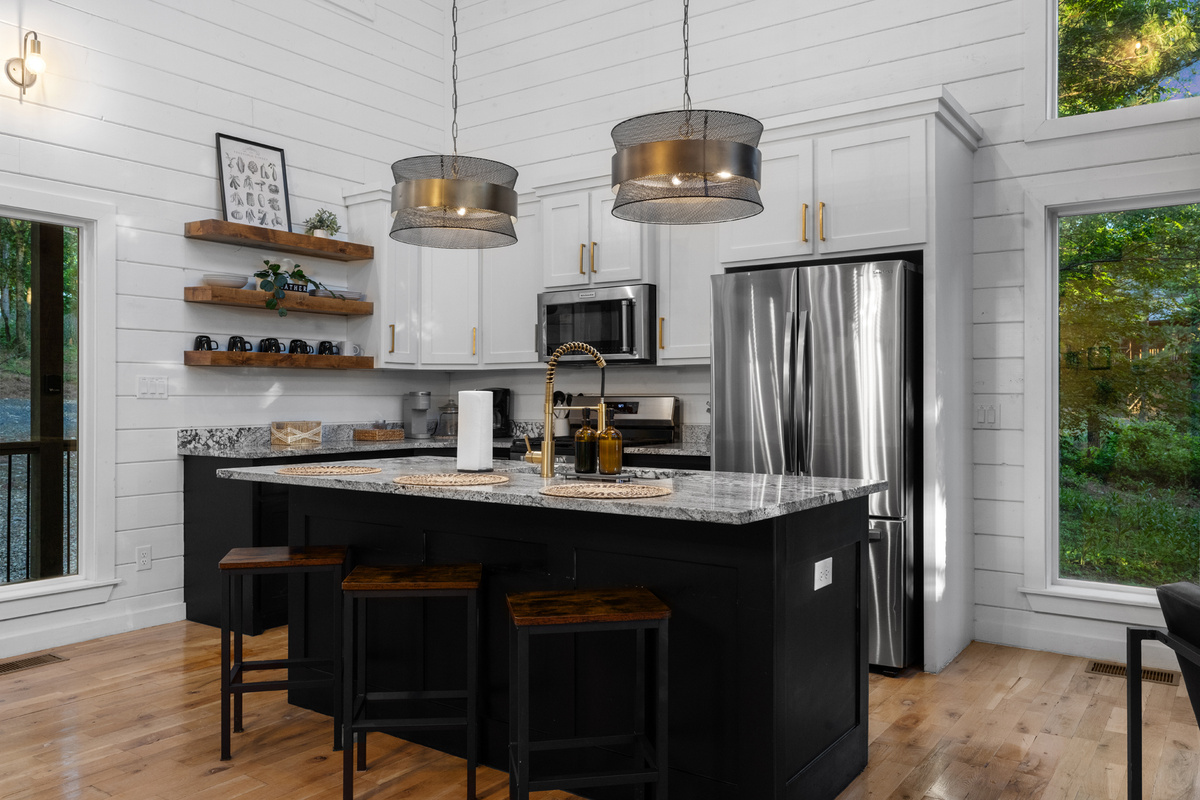 A functional kitchen space with sink, cookware, and dinnerware provided, making it simple to cook, serve, and enjoy meals at the cabin