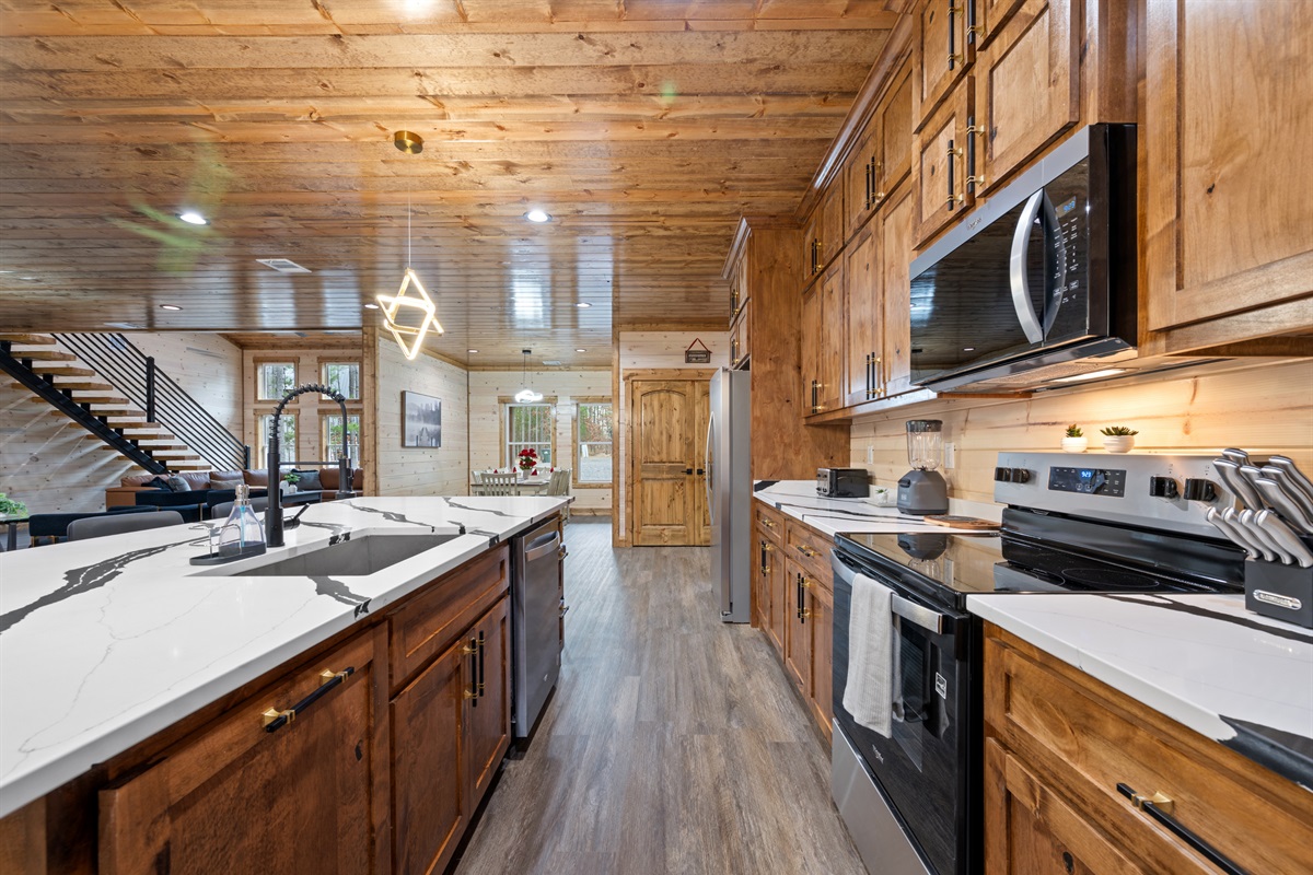 The kitchen stretches out with ample cabinetry and workspace, giving everyone plenty of room to help with cooking.