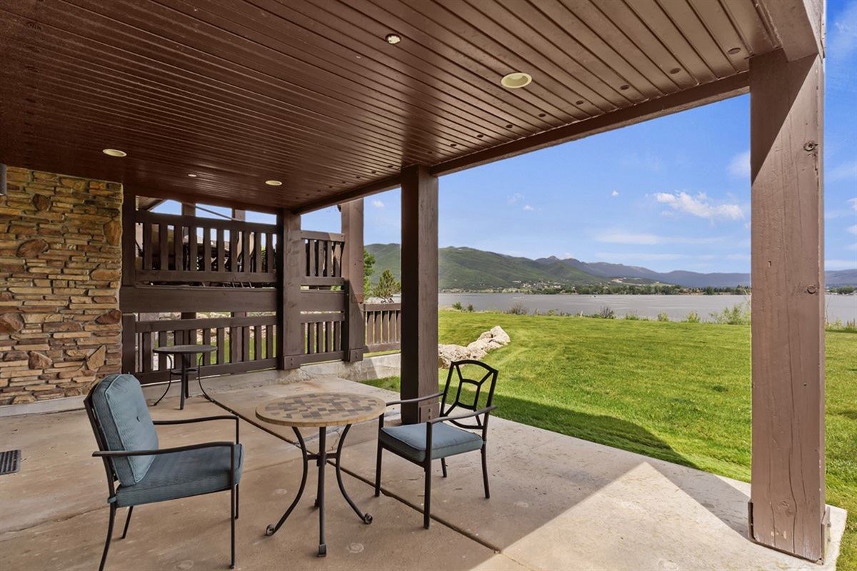 Covered patio retreat with comfortable seating and tranquil lake views—ideal for year-round outdoor living.