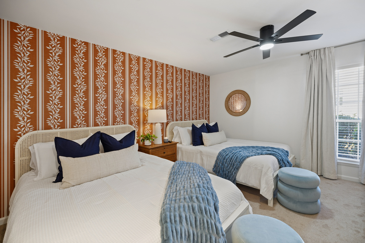 The Orange Suite: two queens, cane headboards, and Auburn orange floor to ceiling. Four of you get real beds in this room alone.