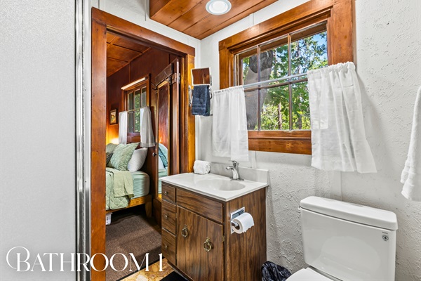 A second bathroom with a shower and forest views makes mornings easy for your whole group.