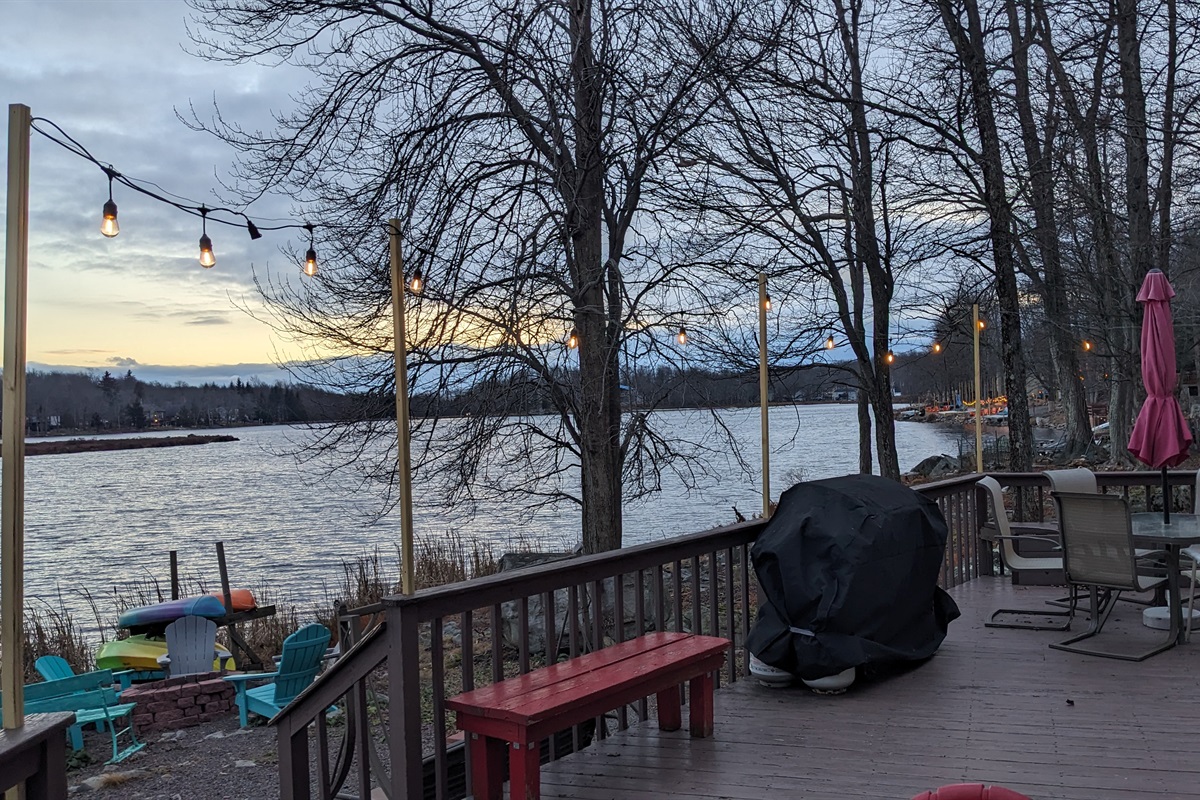 Evening view of the lake from the wooden deck enhanced with string lights