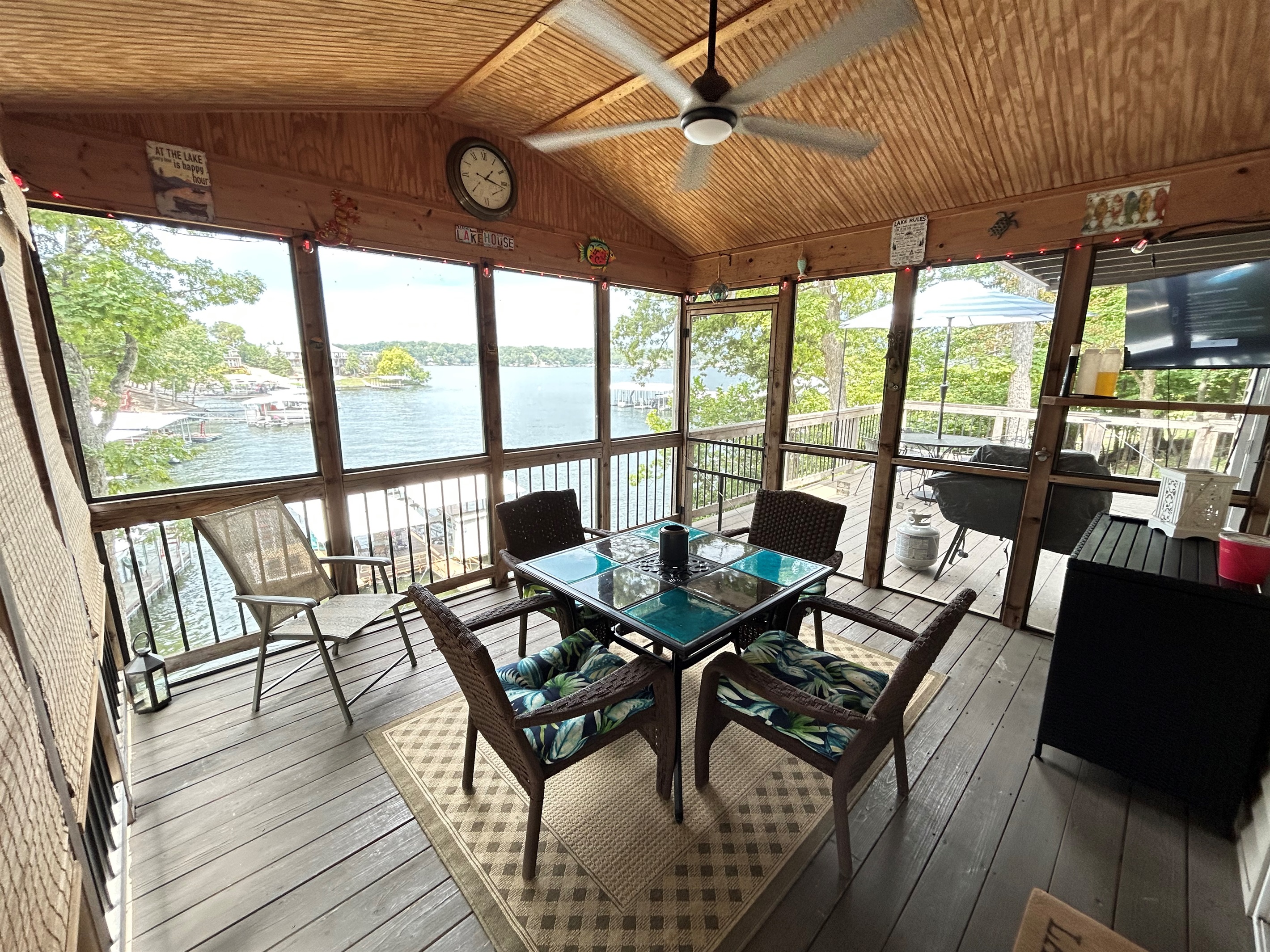 Covered deck overlooking lake with TV