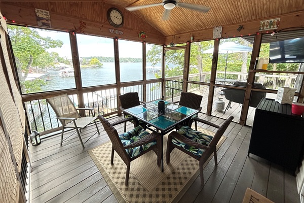 Covered deck overlooking lake with TV