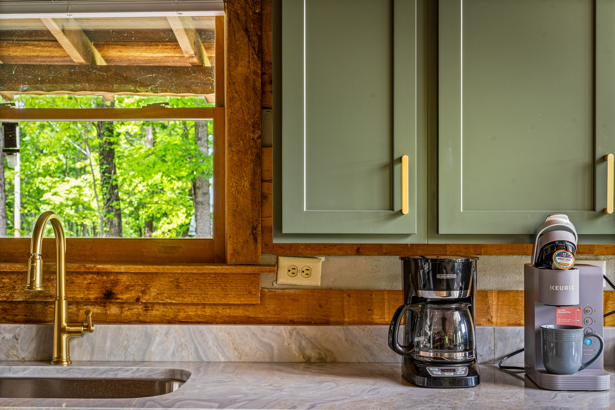 Coffee area with a coffee pot, a Keurig coffee maker, and plenty of coffee mugs.
