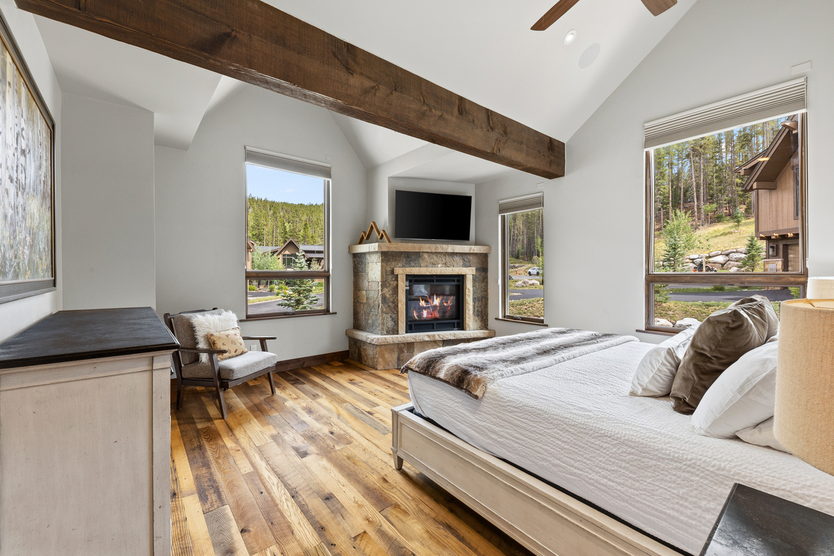 Primary bedroom with King bed, lots of space, gas fireplace and abundant natural light from multiple windows (all windows have blinds that lower from top or raise from the bottom). 