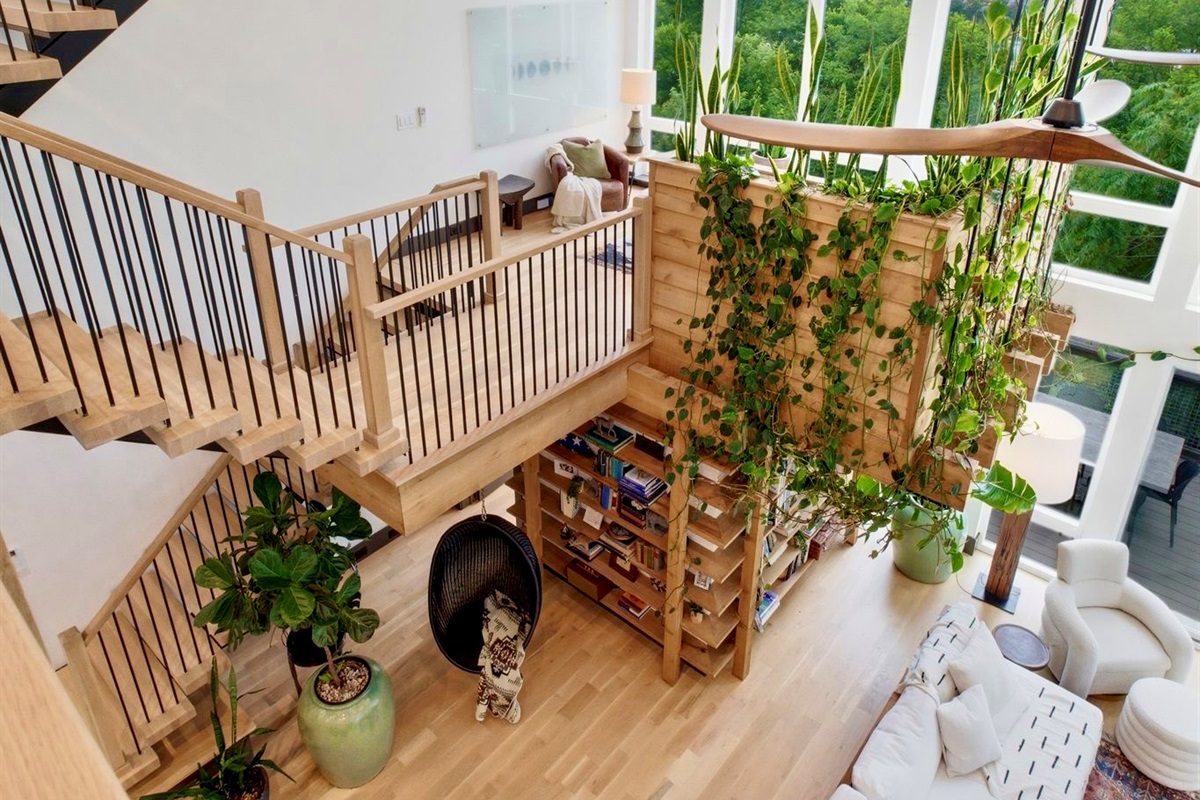 Dramatic double-height staircase wrapped in trailing vines — every inch a visual moment.
