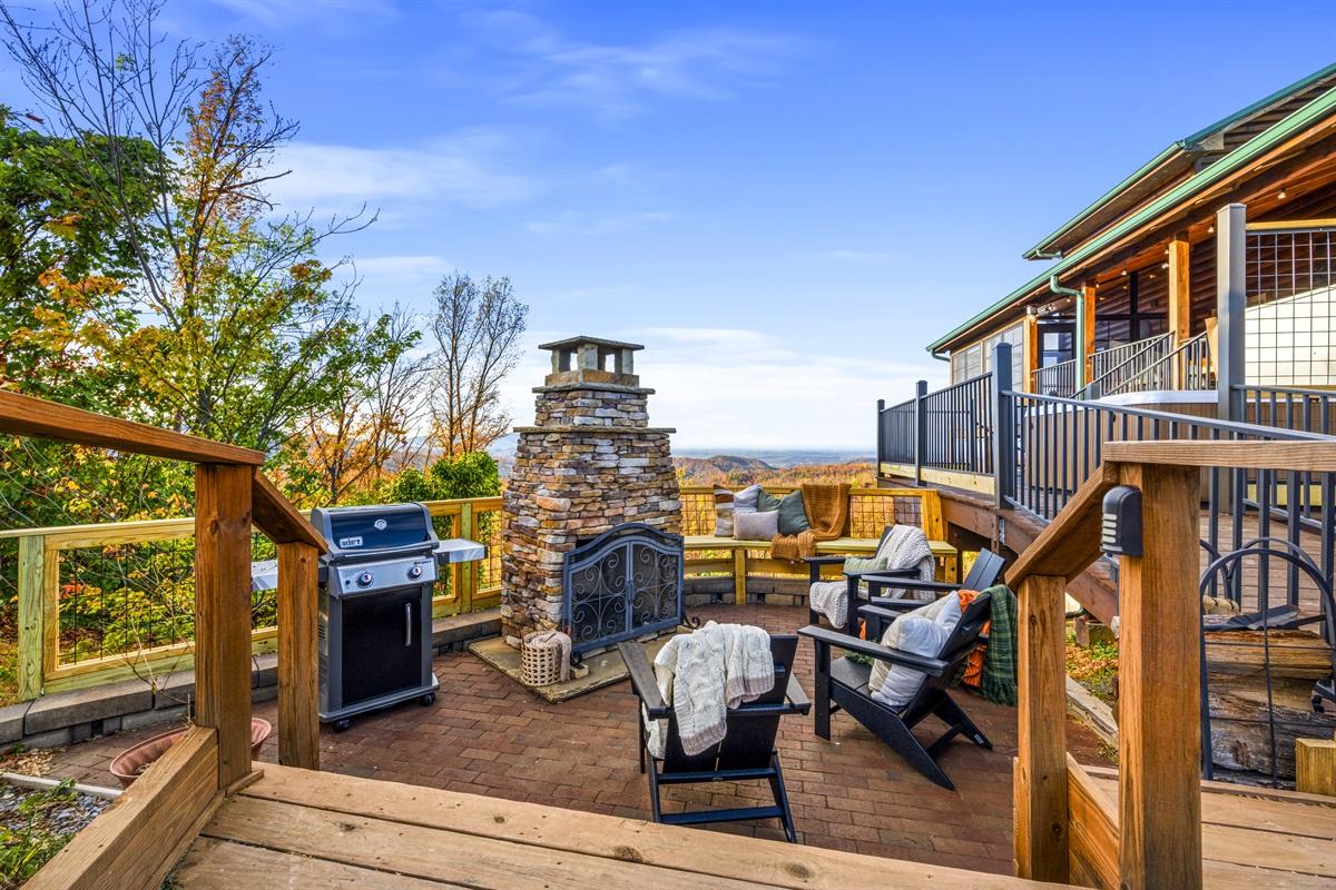 Cozy up by the outdoor wood-burning fireplace at Signature Stay, where crackling flames meet stunning mountain views for an unforgettable evening