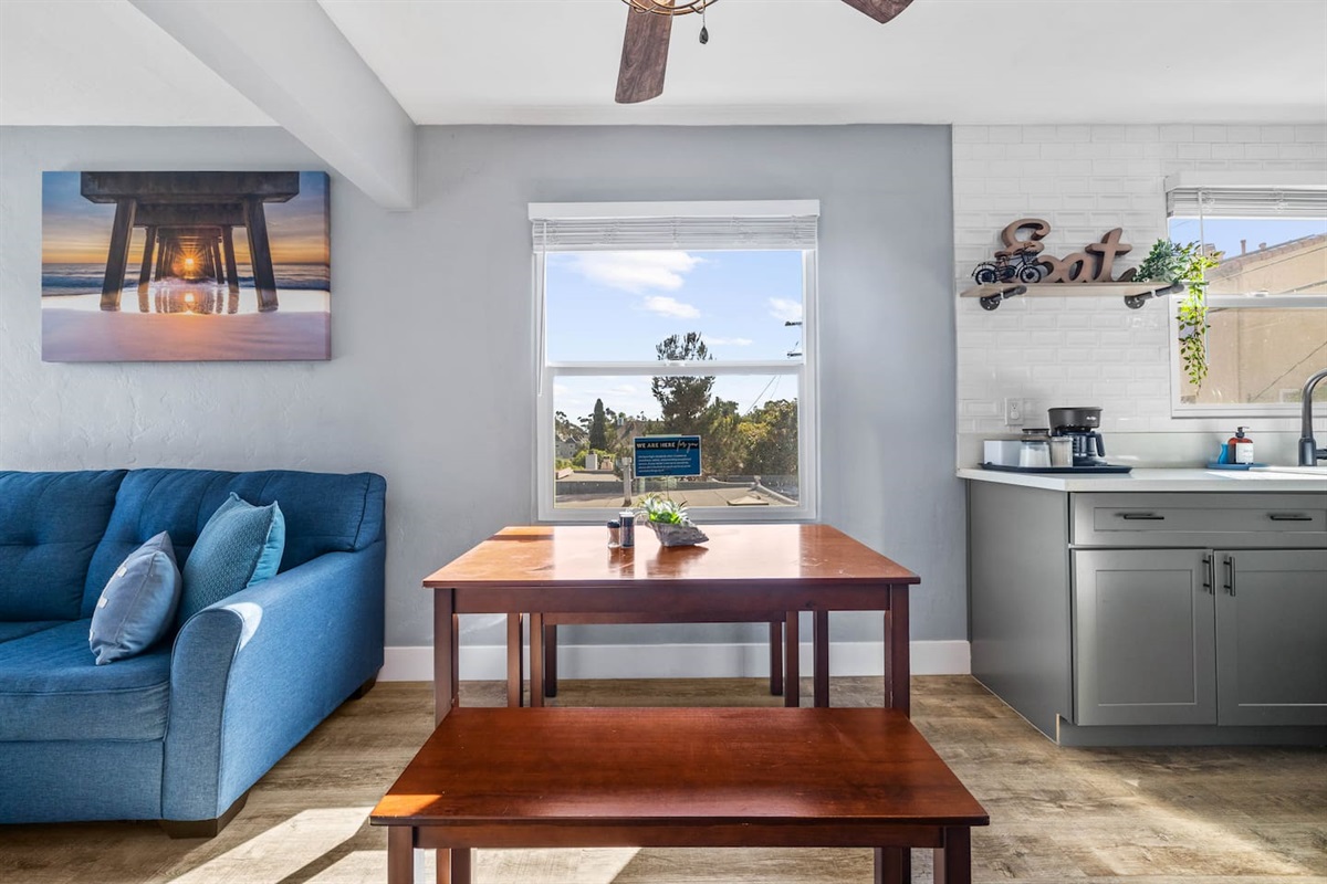 Enjoy meals in a bright dining area with a refreshing ceiling fan and a lovely view from the window. A cozy space perfect for gathering and relaxing during your stay!