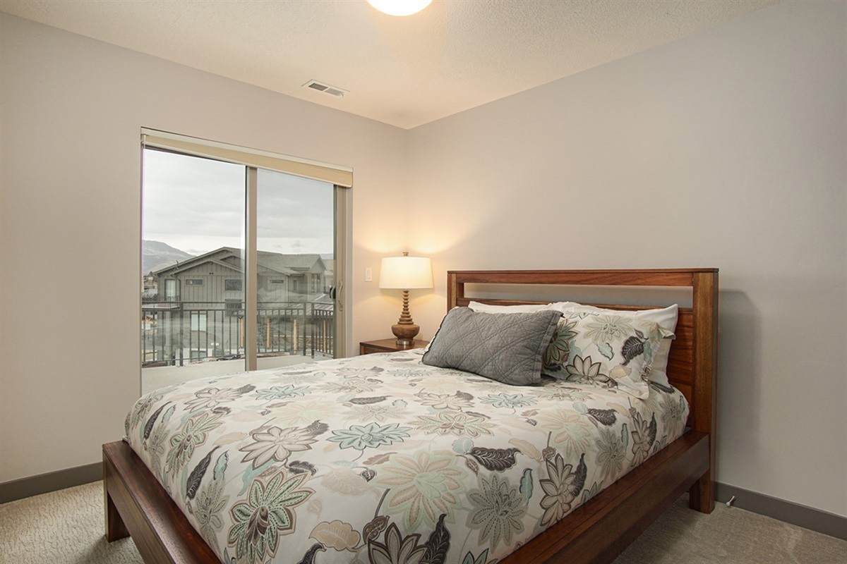 Another inviting guest bedroom with a queen bed and calming tones, perfect for hosting family or friends in comfort.