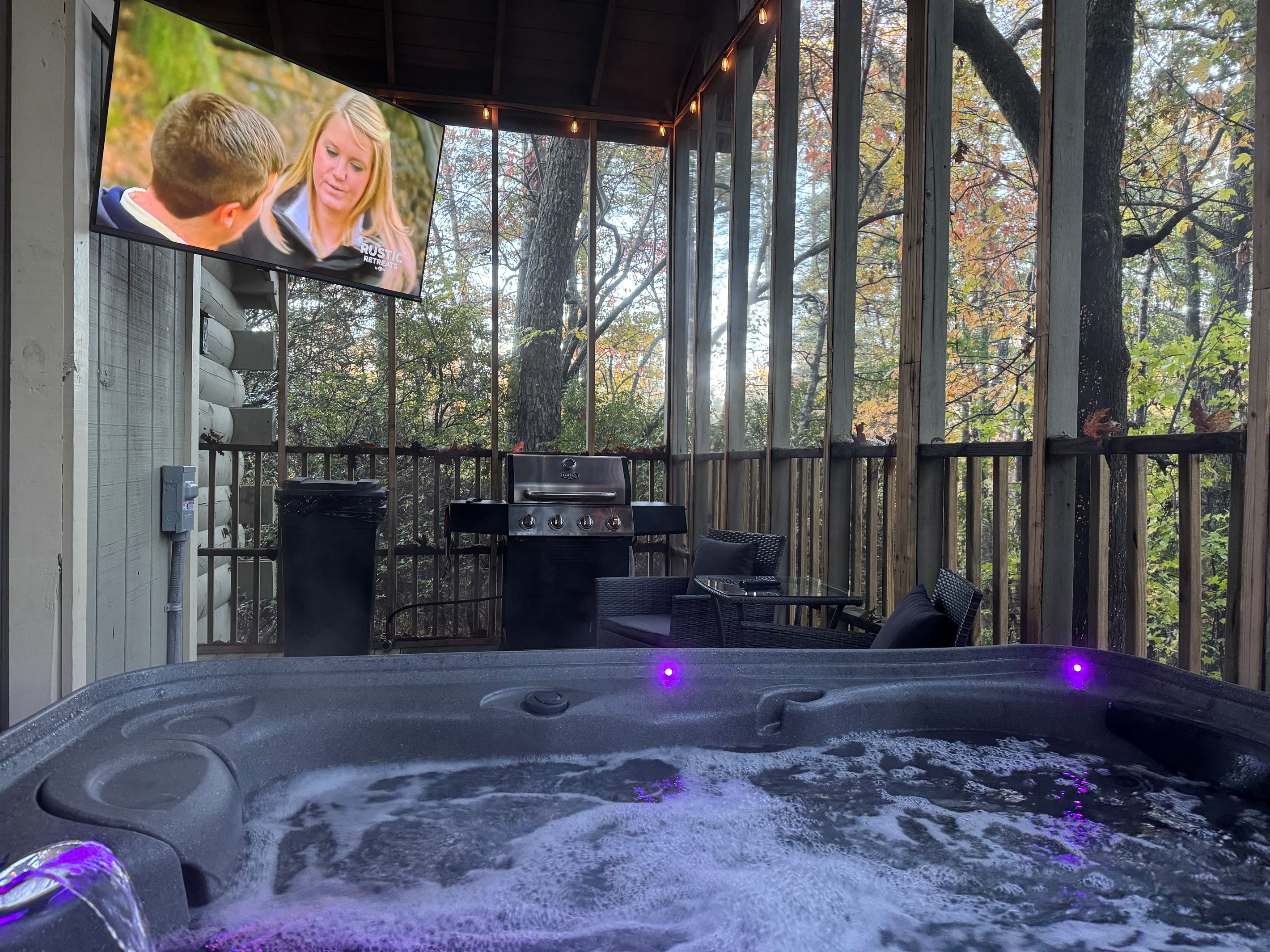 Private hot tub with forest views, outdoor seating, and grill for relaxing nights.