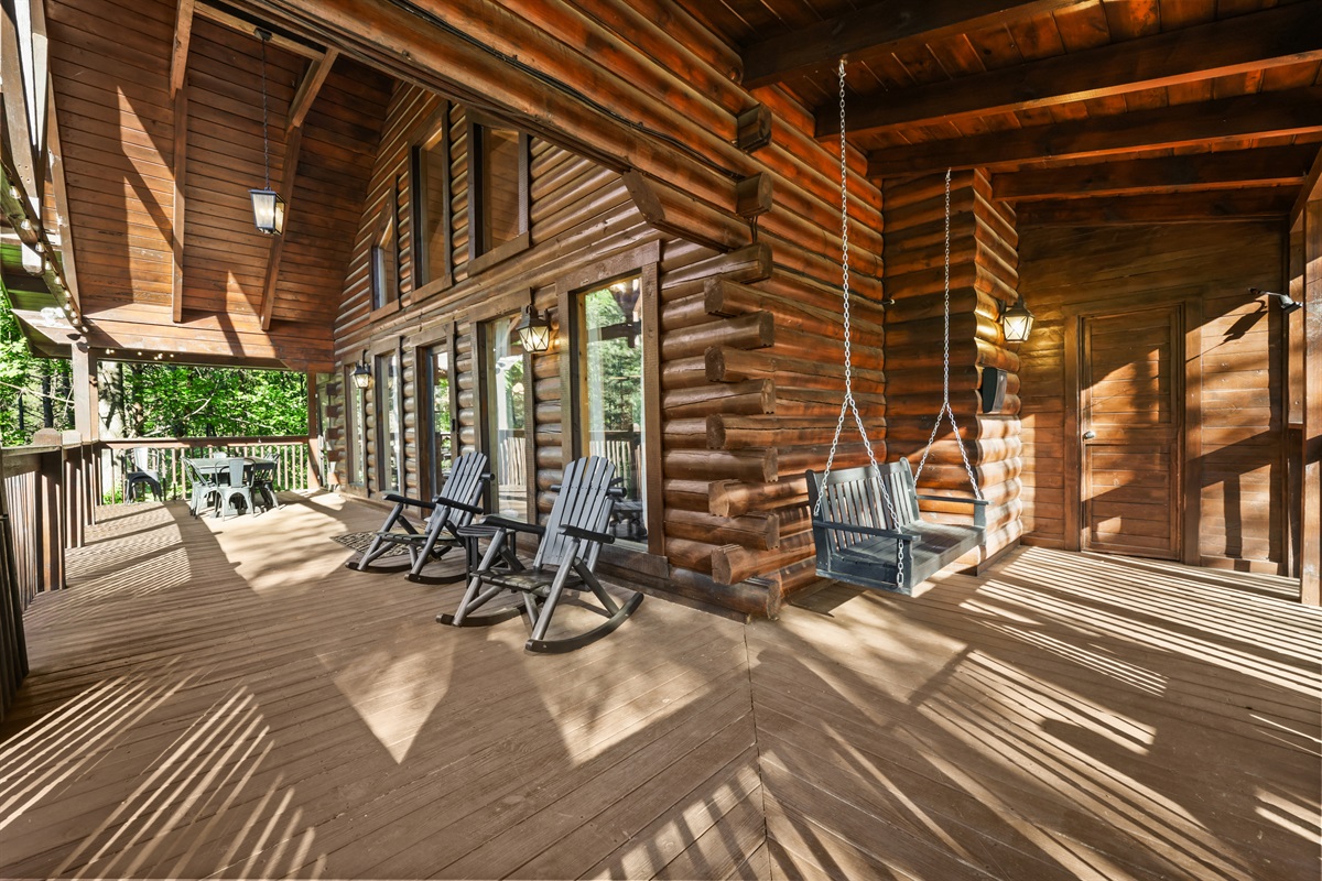 Upper deck with porch swing and rocking chairs. On this deck you will also find a large outdoor dining table and chairs