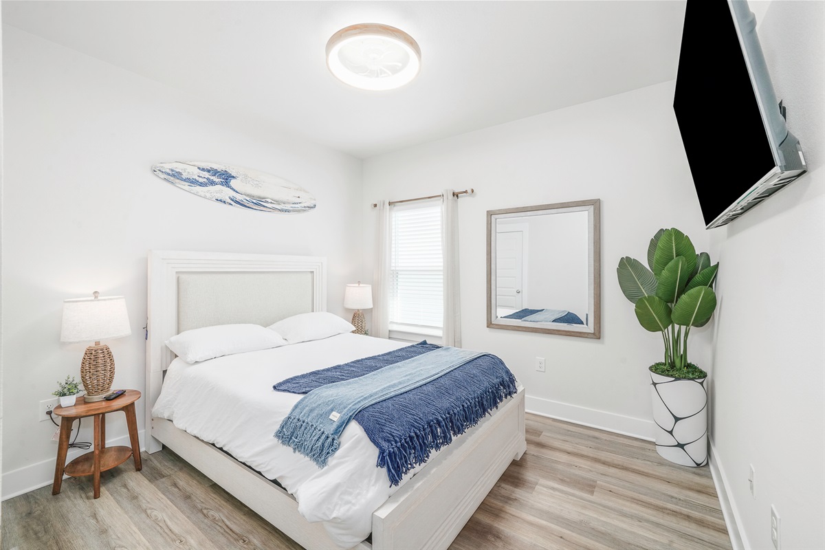 Bedroom 3: Queen bedroom, plush linens, ceiling fan, bedside lamps, wall art, and Smart TV.