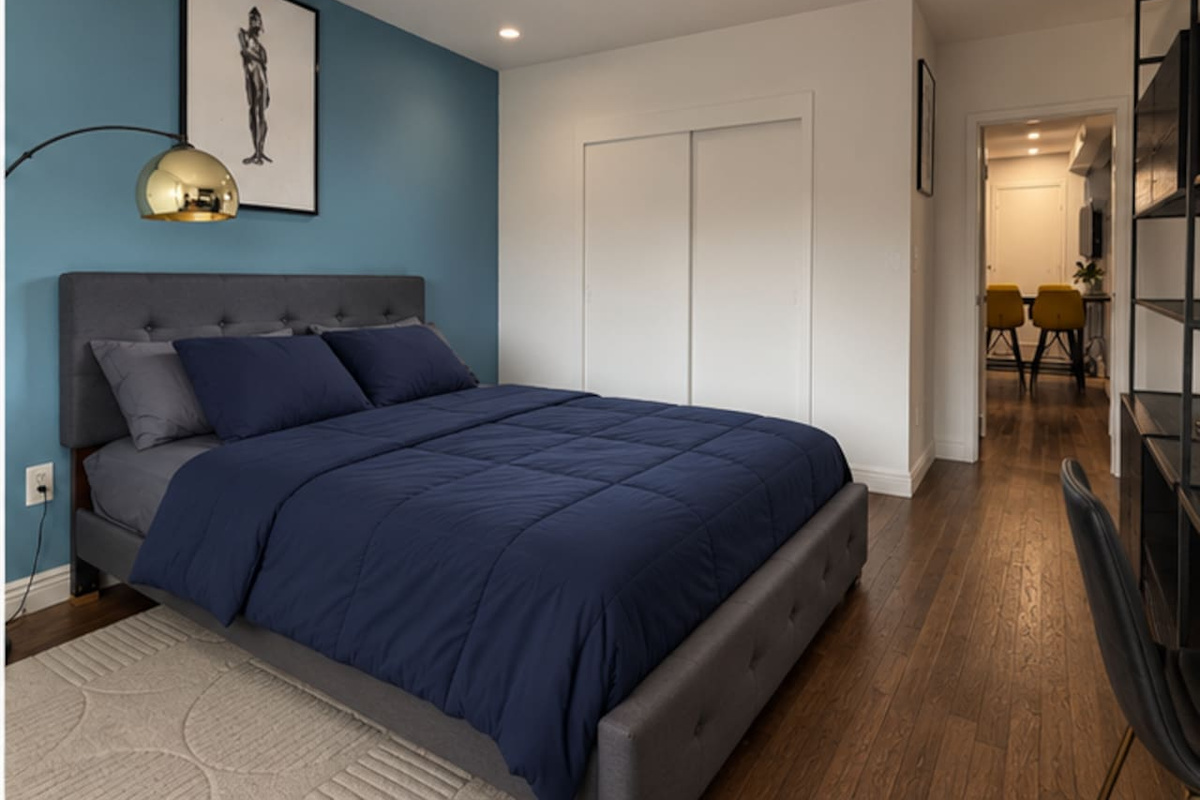 Primary bedroom with built-in closet storage — modern Little Italy NYC apartment rental"