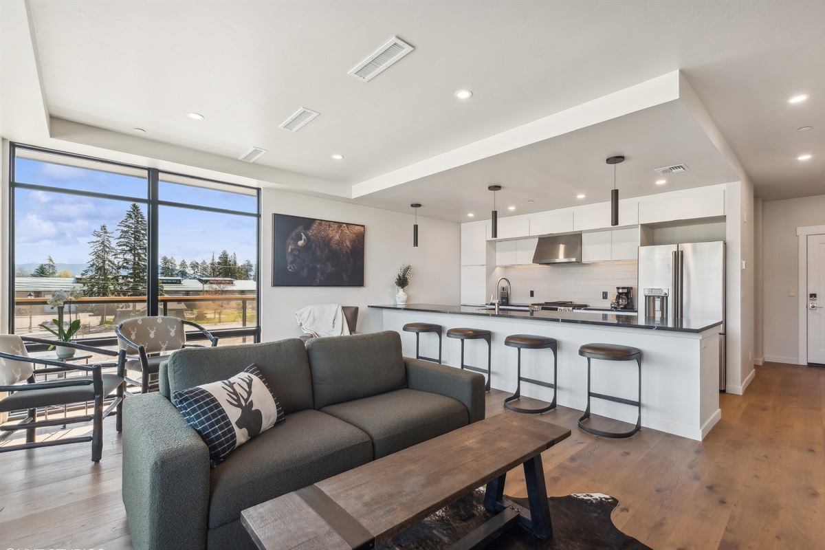 Main living space with open modern living room and kitchen. The living room features a luxury queen sofa sleeper.