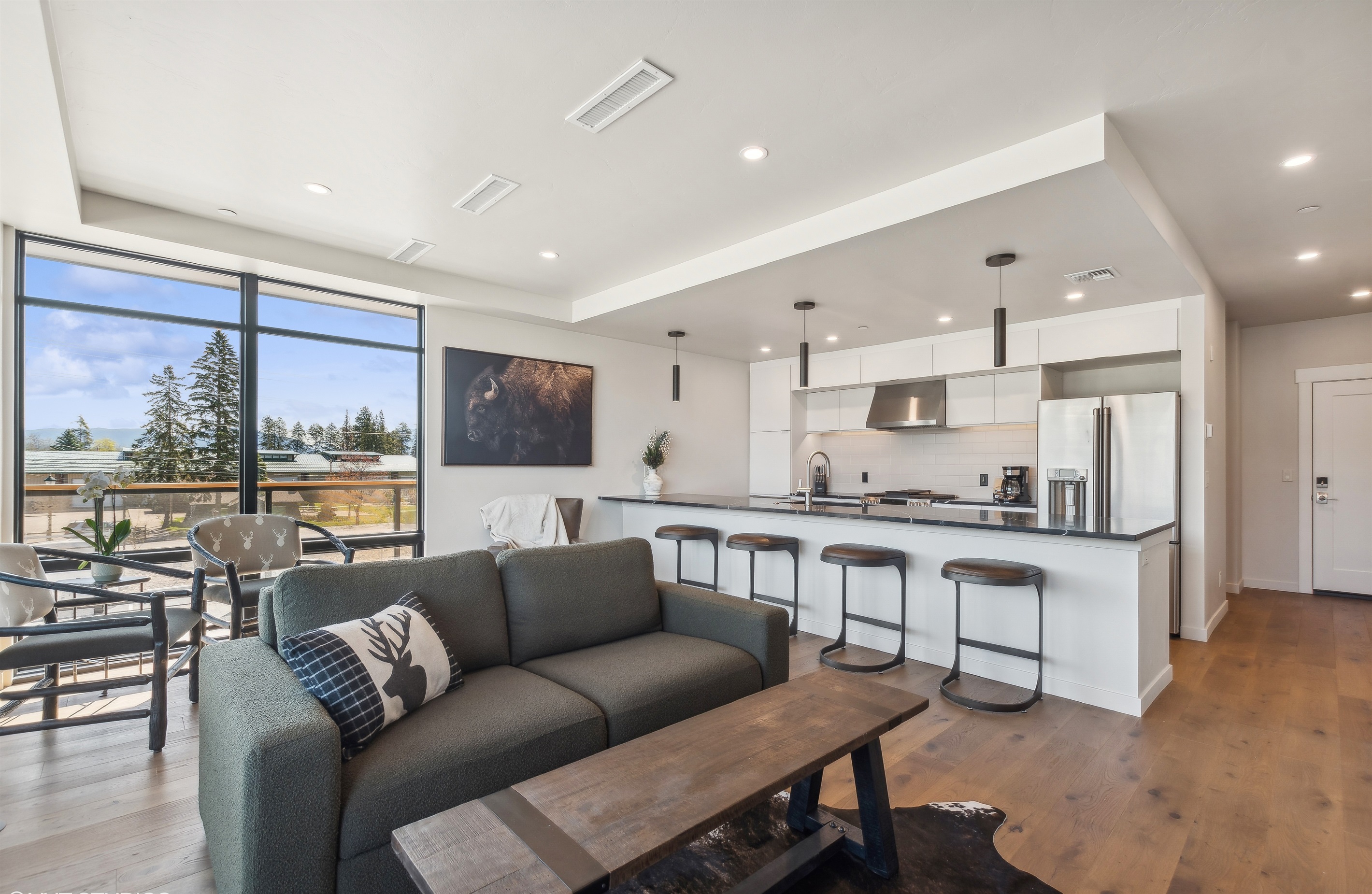 Main living space with open modern living room and kitchen. The living room features a luxury queen sofa sleeper.