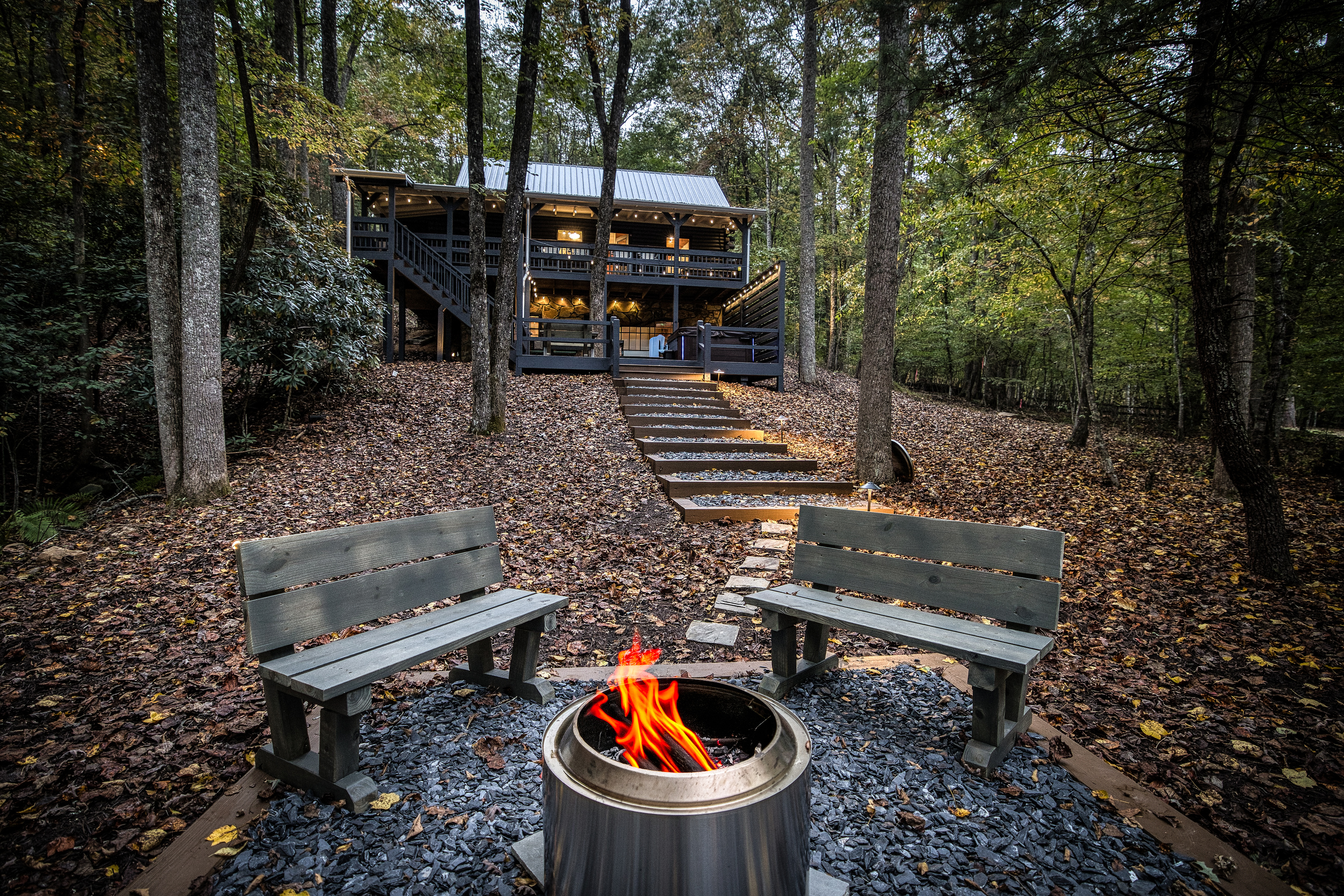 Fire pit with benches in the woods.