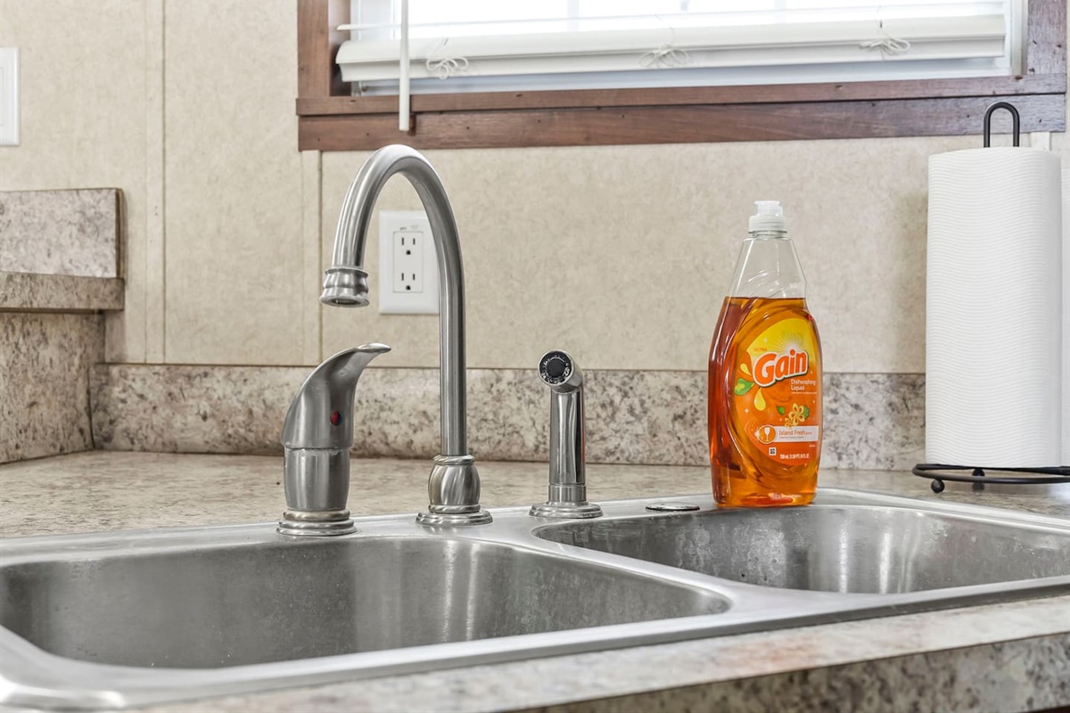Close-up of the double sink with modern faucet and essentials—designed for convenience during your stay.