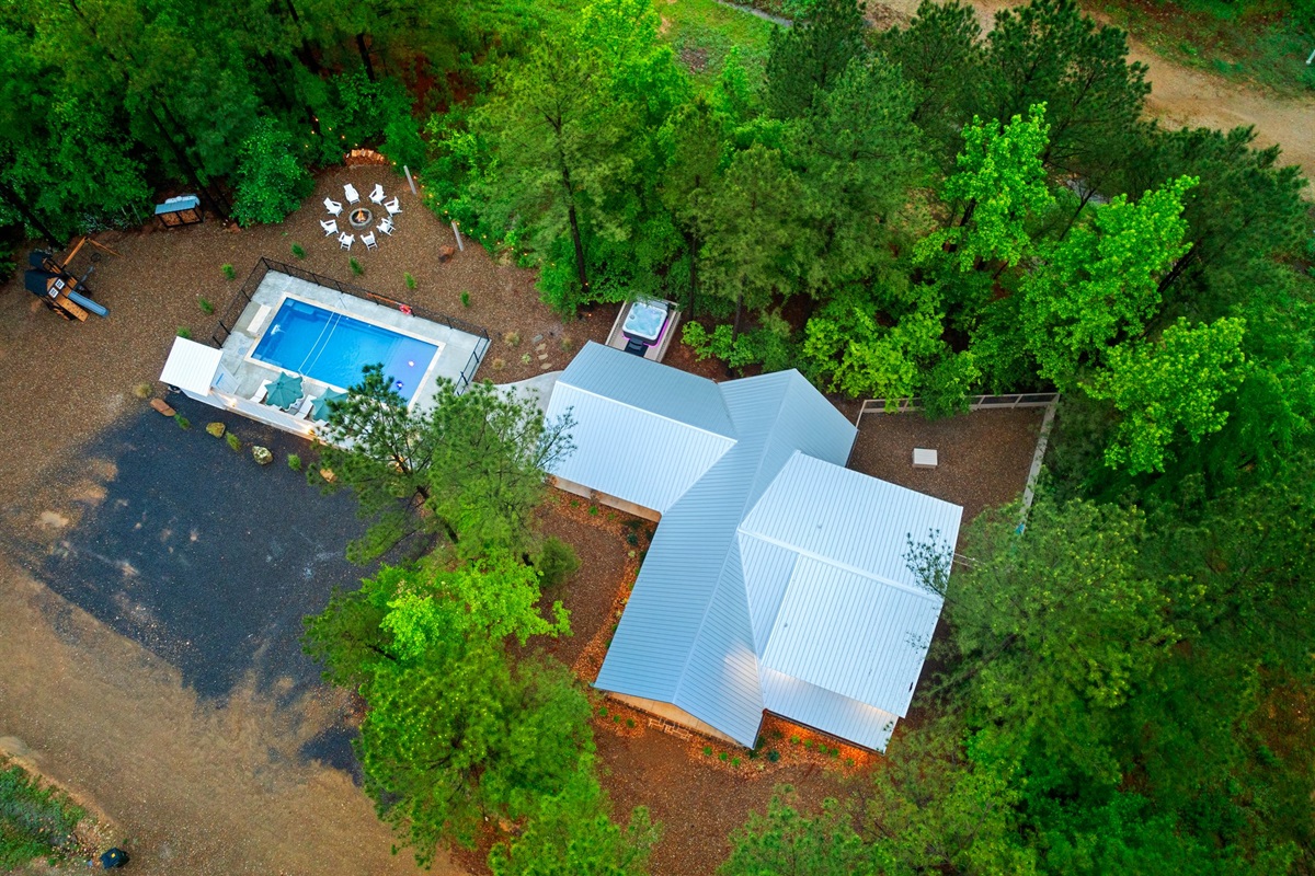 From above, the layout comes to life. Pool days, firepit nights, hot tub moments, patio hangs, playset fun, a fenced yard for pups, and convenient parking just steps away.