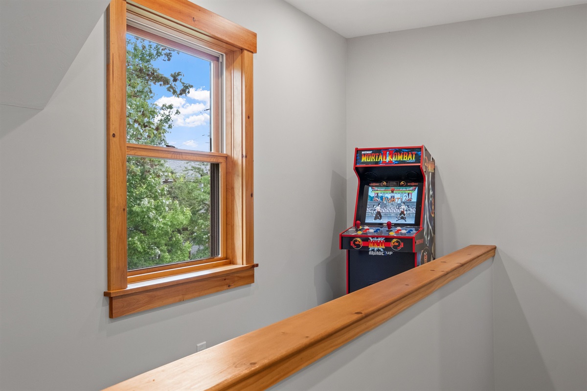 Arcade game in the second floor loft bedroom with queen bed and bath just outside the door