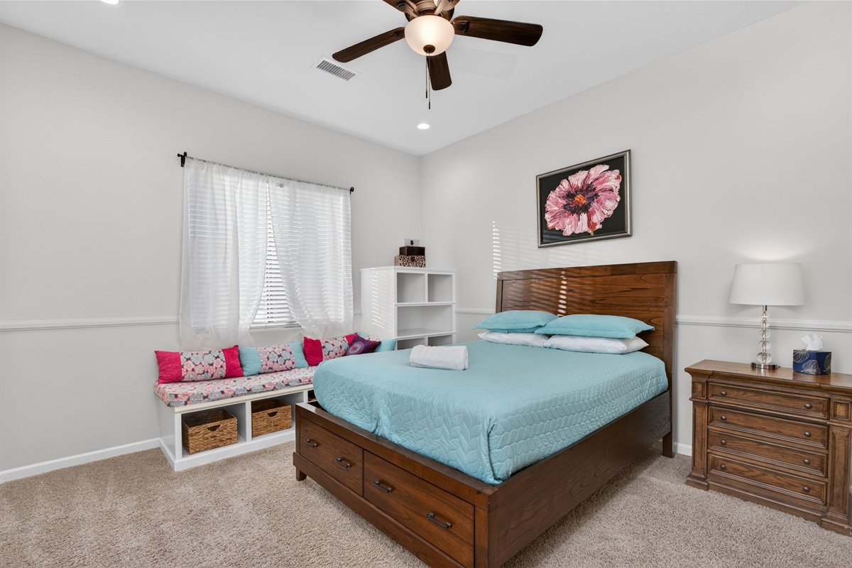 Comfortable first-floor guest bedroom with queen bed and natural light ideal for families or additional guests