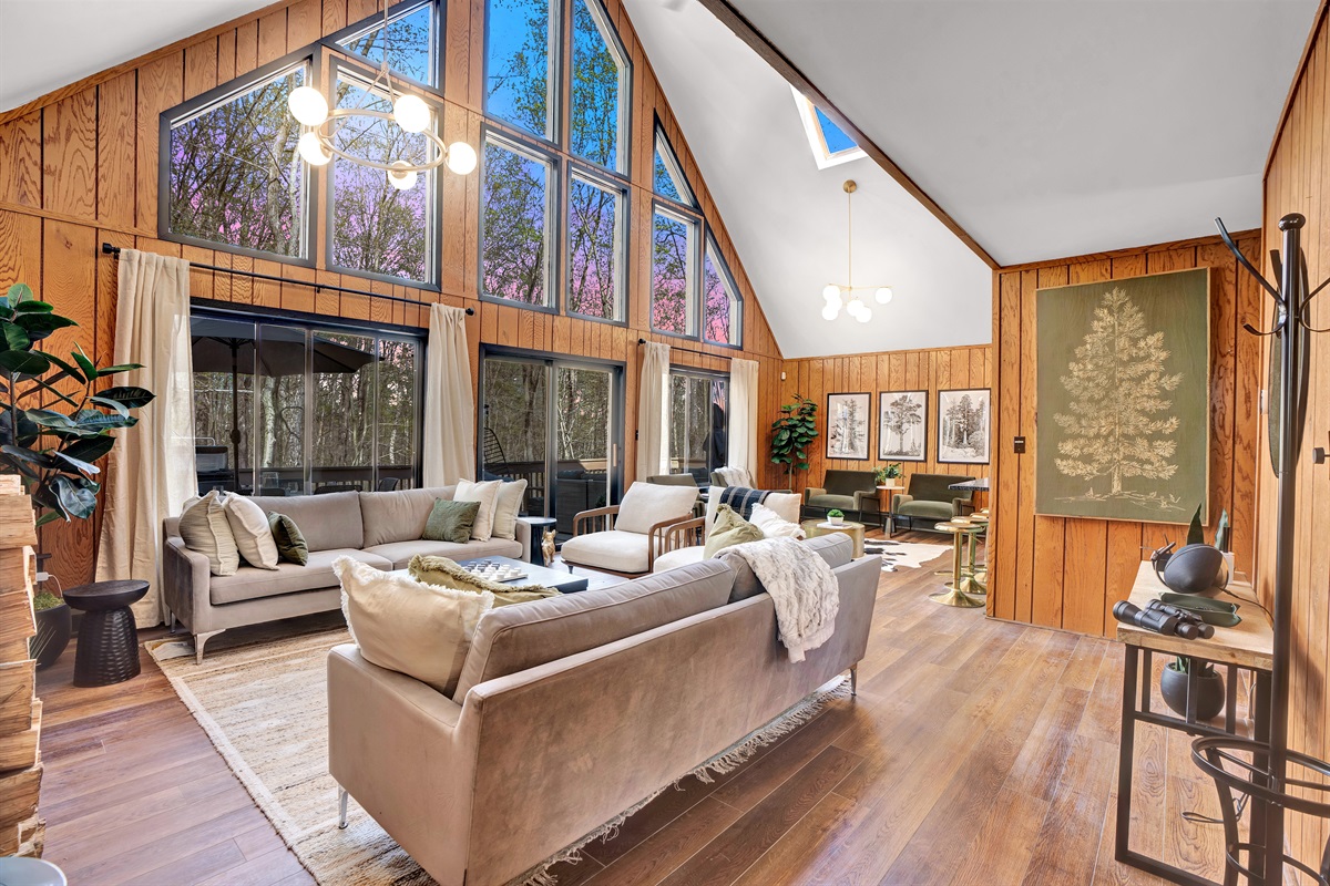 “Welcome to our open living room with cathedral ceilings and breathtaking forest views.”