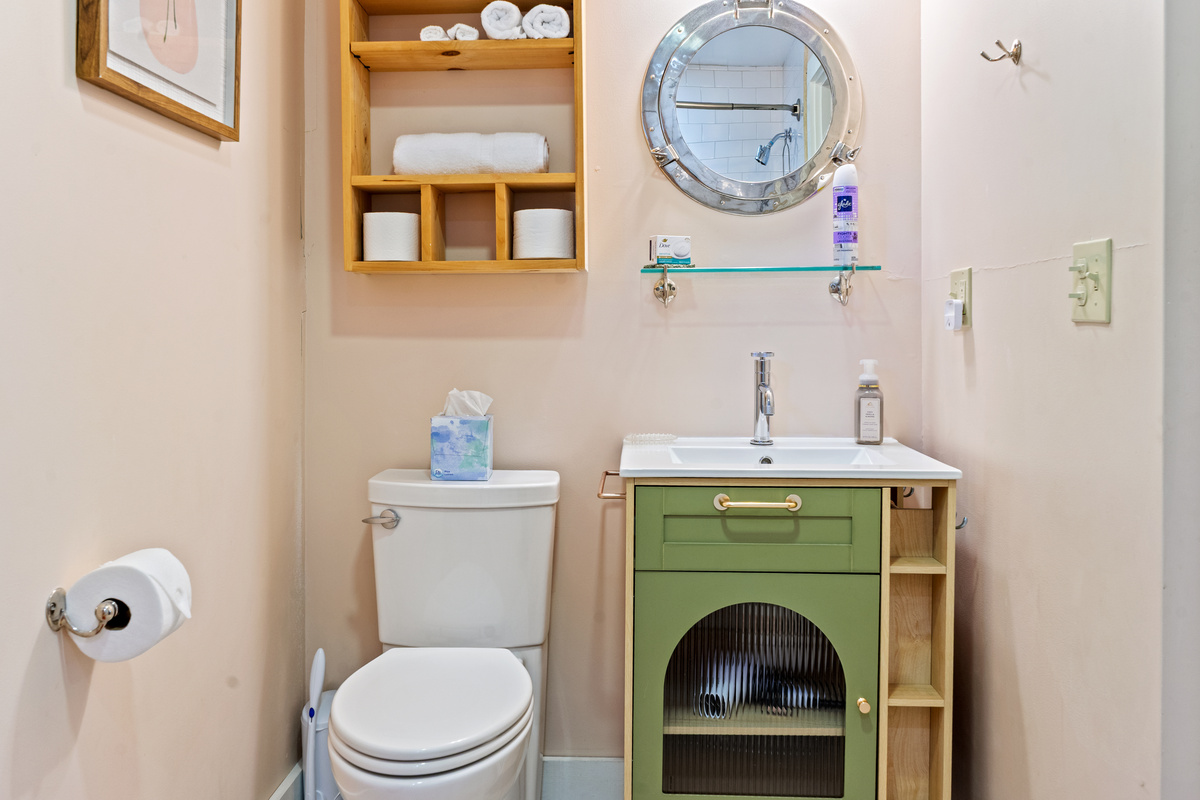 Refreshing the crew's wing with dedicated ship-inspired design. Anchored by a matching sage green vanity, ribbed glass cabinetry, and a gleaming porthole mirror, this space keeps the nautical narrative alive for the second King wing.