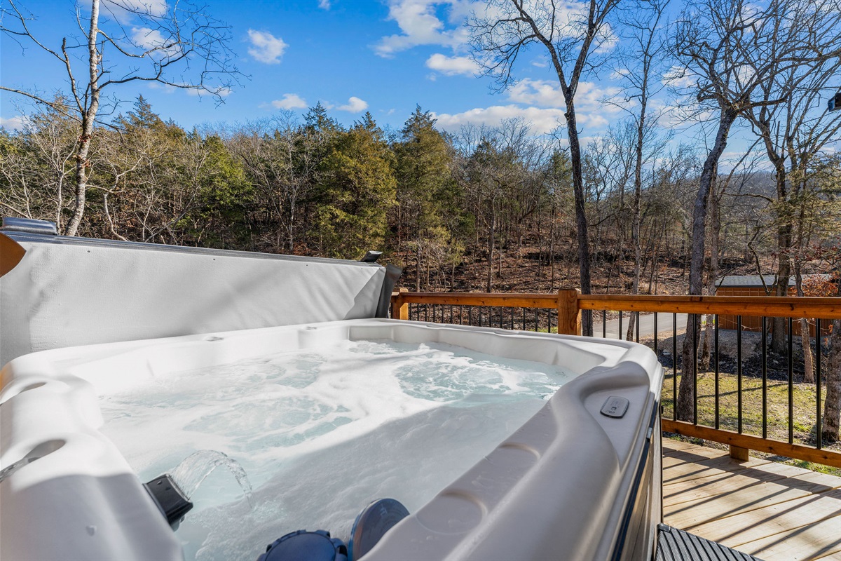 Hot tub with tranquil tree-lined views, creating a calm, refreshing escape.
